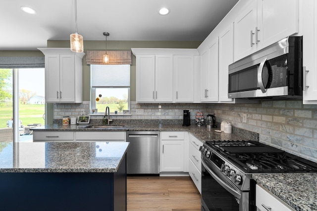 kitchen featuring appliances with stainless steel finishes, a sink, plenty of natural light, white cabinetry, and recessed lighting