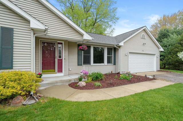 view of front of property featuring driveway, an attached garage, and a shingled roof