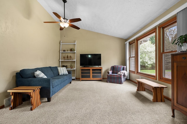 living area with lofted ceiling, carpet floors, a ceiling fan, and a textured ceiling