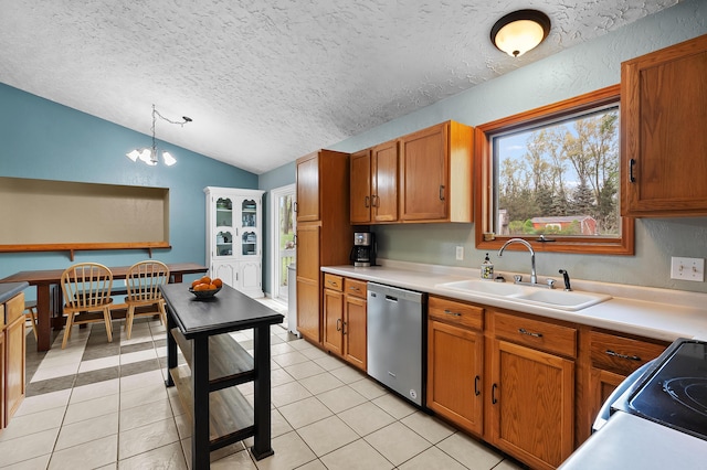 kitchen featuring stainless steel dishwasher, a sink, a textured ceiling, lofted ceiling, and brown cabinetry