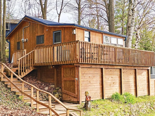 rear view of property featuring stairs and a deck