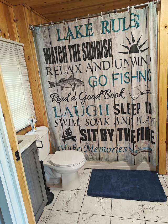 full bath featuring toilet, curtained shower, wooden walls, and tile patterned flooring