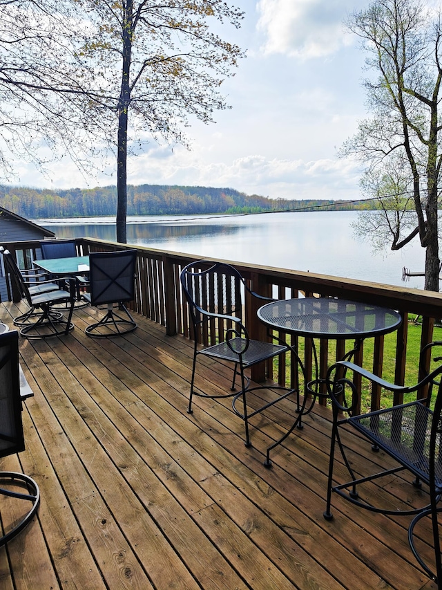 wooden deck featuring outdoor dining area and a water view