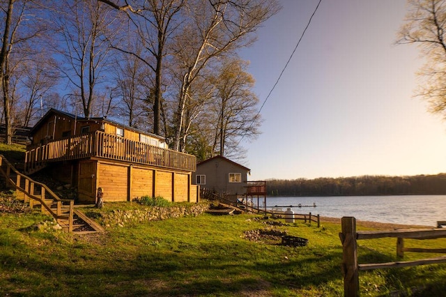 6294 Rock Rd, Lake, MI 48632 - yard at dusk with a deck with water view, stairway, a yard, and an attached garage