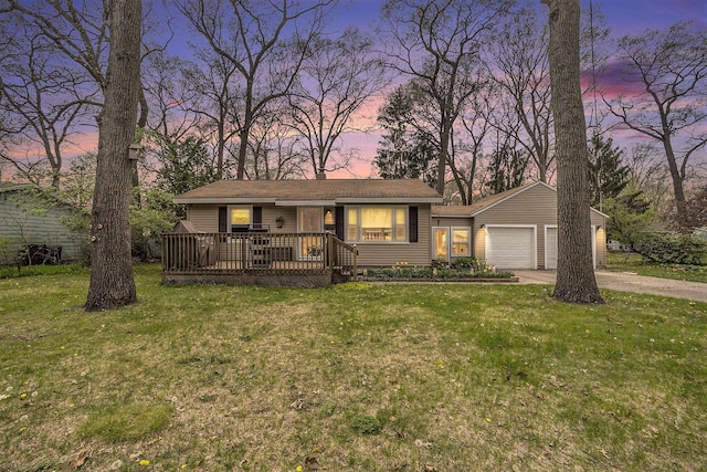 ranch-style house featuring a garage, a yard, concrete driveway, and a deck