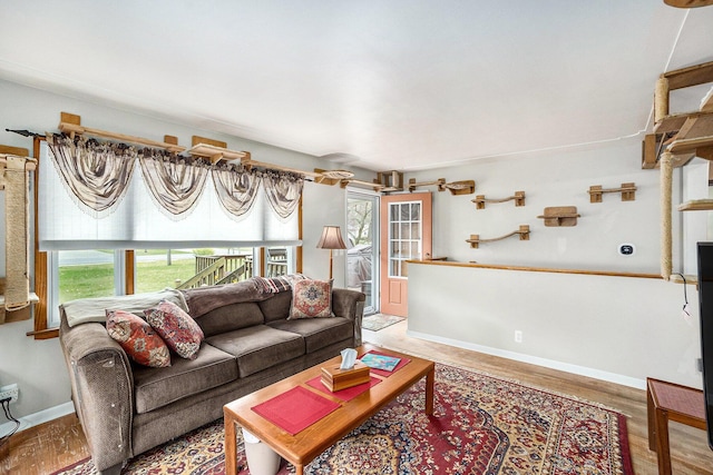 living area featuring healthy amount of natural light, light wood-style floors, and baseboards