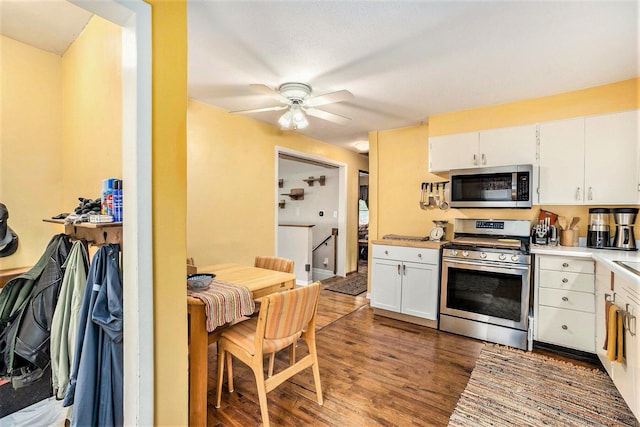 kitchen featuring stainless steel appliances, white cabinetry, ceiling fan, dark wood finished floors, and light countertops