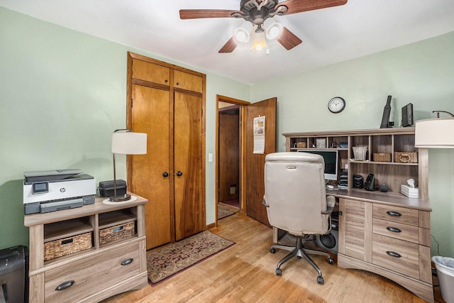 home office with light wood-type flooring and ceiling fan