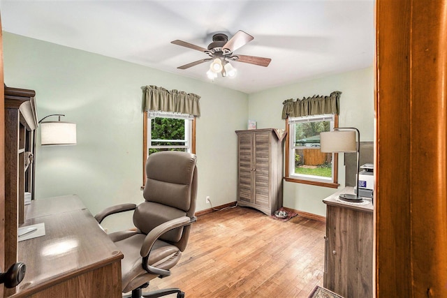 office space with a ceiling fan, light wood finished floors, and baseboards