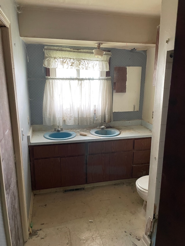 9550 Colgate Ave, Clarkston, MI 48348 - bathroom featuring double vanity, tile patterned floors, and toilet