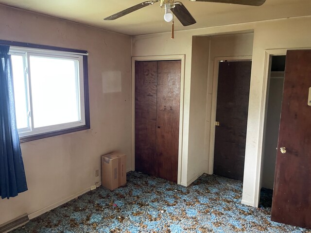 9550 Colgate Ave, Clarkston, MI 48348 - unfurnished bedroom featuring multiple closets and a ceiling fan