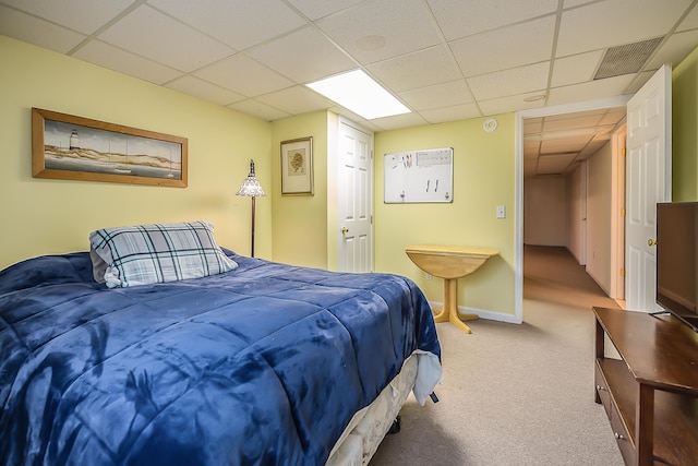 carpeted bedroom featuring a paneled ceiling and baseboards