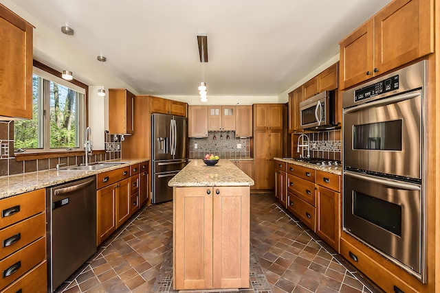kitchen featuring appliances with stainless steel finishes, a sink, and brown cabinets