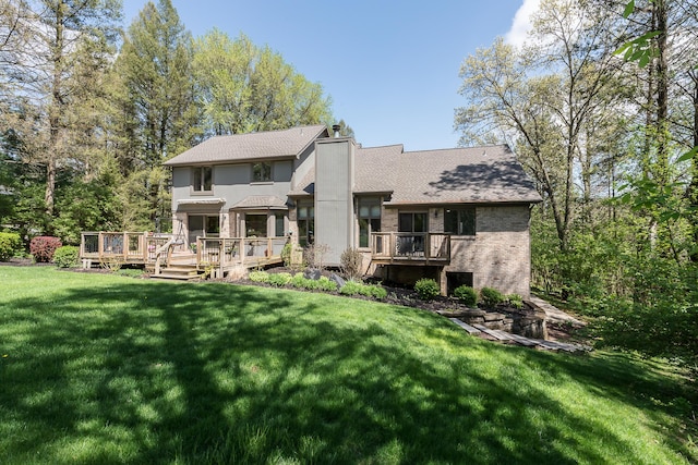 rear view of property with brick siding, a wooden deck, a yard, a chimney, and a shingled roof