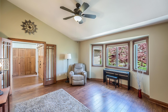 sitting room featuring lofted ceiling, wood finished floors, baseboards, and a ceiling fan