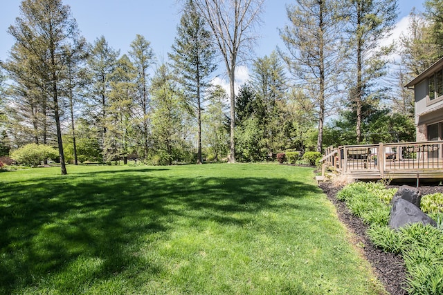 view of grassy yard with a deck