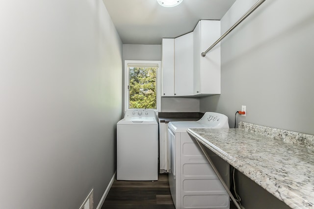 clothes washing area featuring independent washer and dryer, cabinet space, and dark wood-style floors