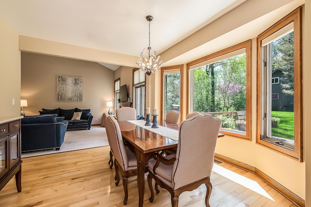 dining space with a chandelier, healthy amount of natural light, and light wood-type flooring