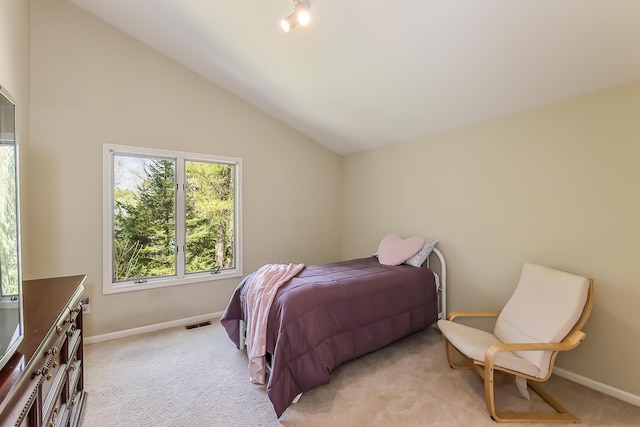 bedroom featuring light colored carpet, baseboards, and vaulted ceiling