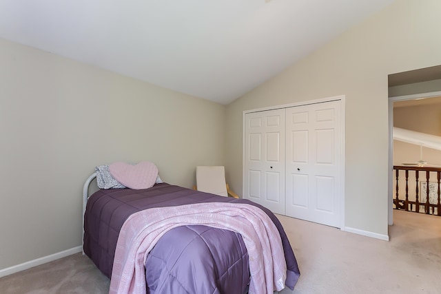 bedroom featuring light carpet, baseboards, vaulted ceiling, and a closet