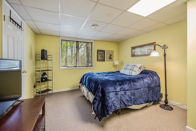 bedroom with carpet floors, a paneled ceiling, and baseboards