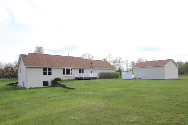 rear view of house featuring a deck and a yard