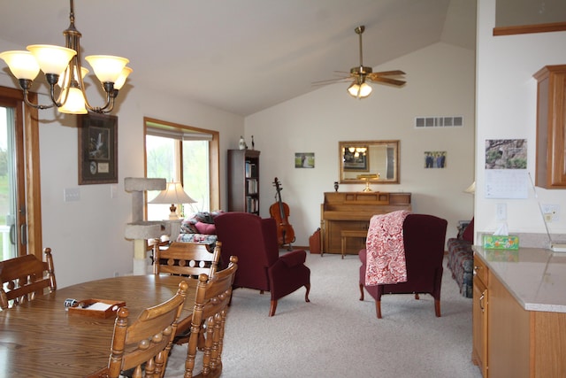 dining space with lofted ceiling, a chandelier, light colored carpet, and a ceiling fan