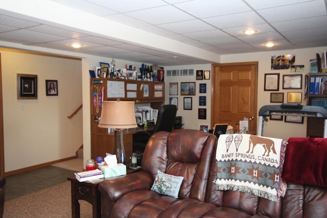 living room with carpet flooring, baseboards, stairs, tile patterned floors, and a drop ceiling