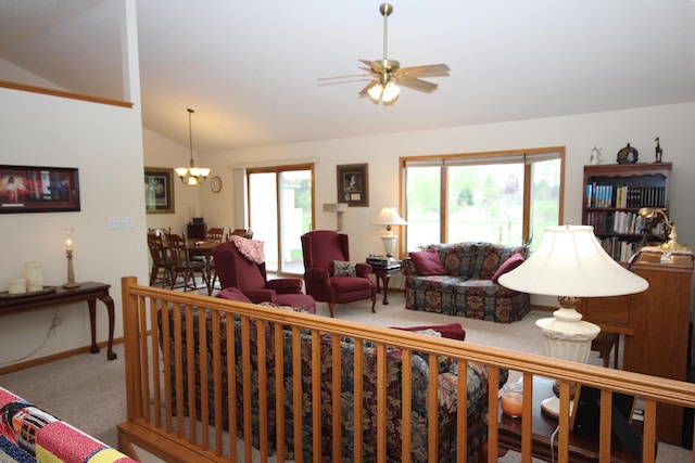carpeted living room featuring vaulted ceiling, healthy amount of natural light, a ceiling fan, baseboards, and a chandelier