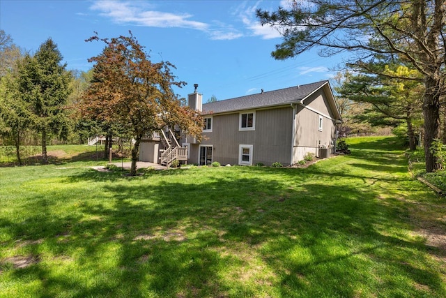 1160 S Baldwin Rd, Lake Orion, MI 48360 - rear view of house with central air condition unit, a chimney, stairway, and a yard
