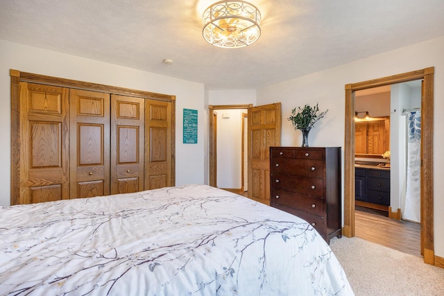 bedroom featuring carpet flooring, a closet, and ensuite bath