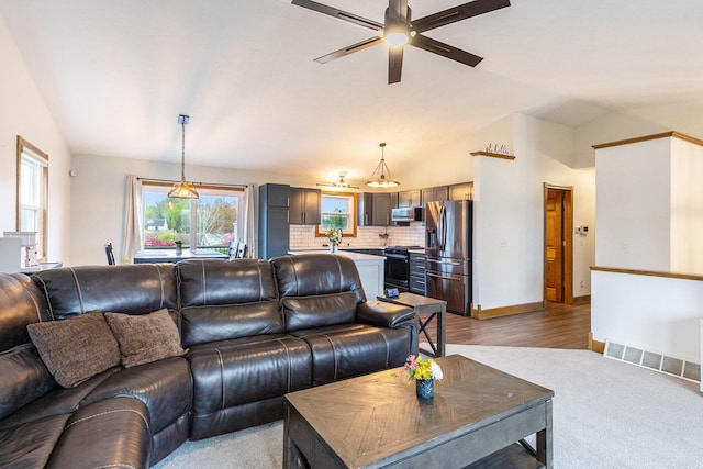 living room featuring ceiling fan, wood finished floors, lofted ceiling, and baseboards