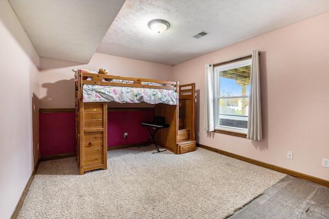 carpeted bedroom with baseboards and a textured ceiling