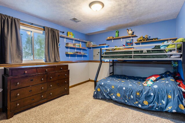 bedroom with carpet flooring, a textured ceiling, and baseboards