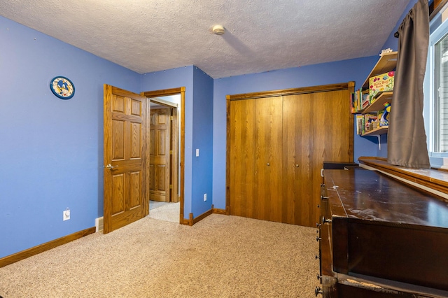 carpeted bedroom with baseboards, a closet, and a textured ceiling