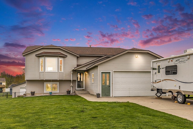 split level home featuring concrete driveway, a garage, and a shingled roof