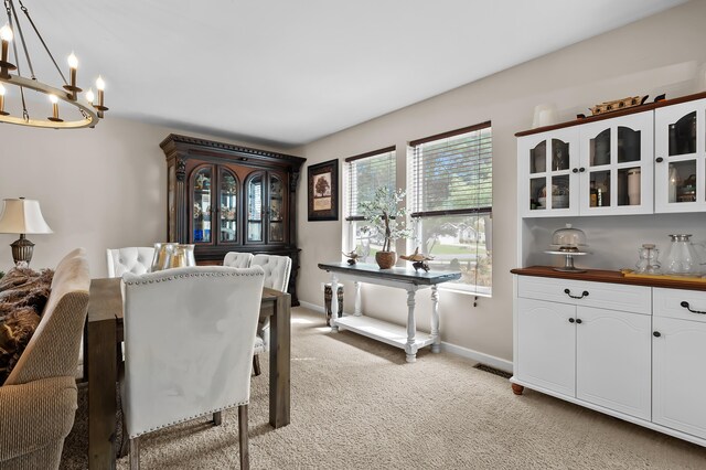 72597 Faye Ct, South Haven, MI 49090 - dining space with a chandelier, light colored carpet, and baseboards