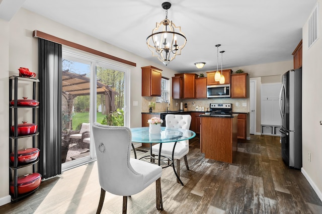 72597 Faye Ct, South Haven, MI 49090 - dining area featuring dark wood-style flooring, a chandelier, and baseboards