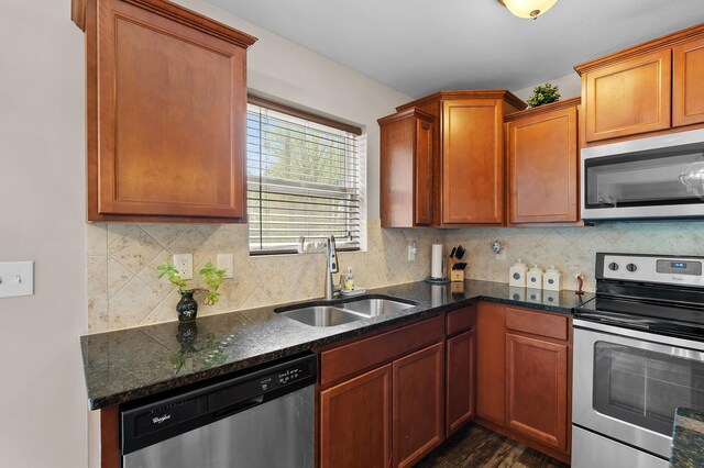 72597 Faye Ct, South Haven, MI 49090 - kitchen featuring appliances with stainless steel finishes, a sink, dark stone counters, and tasteful backsplash