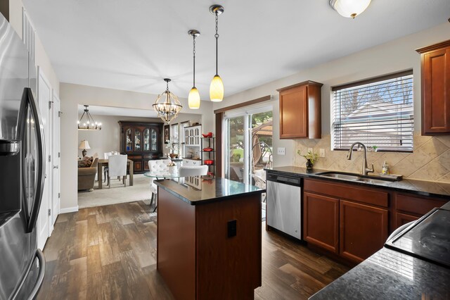 72597 Faye Ct, South Haven, MI 49090 - kitchen with stainless steel appliances, a sink, a chandelier, dark countertops, and dark wood-style flooring