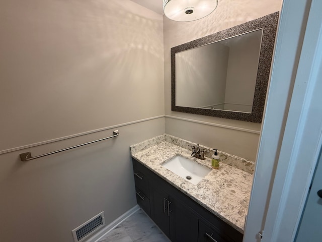 bathroom featuring vanity, marble finish floors, and baseboards