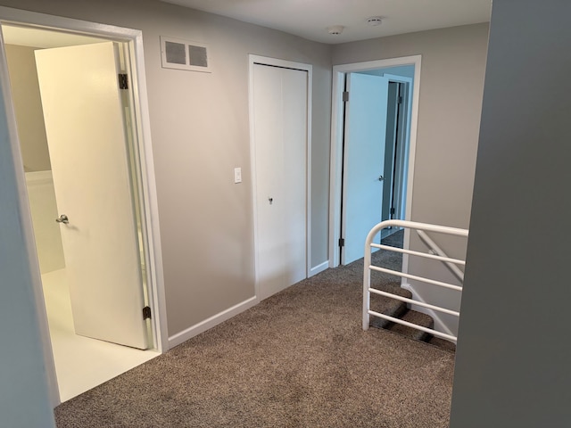 corridor featuring carpet and baseboards