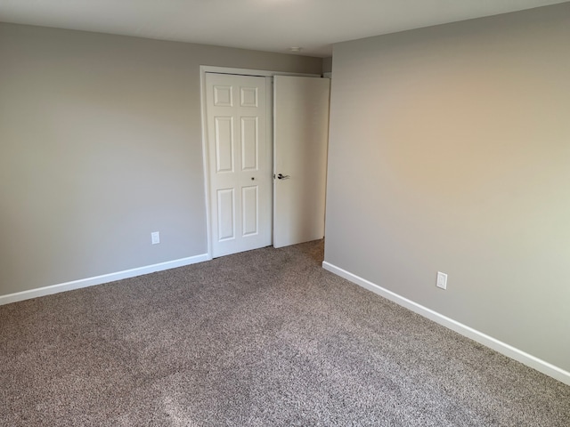 carpeted empty room featuring baseboards