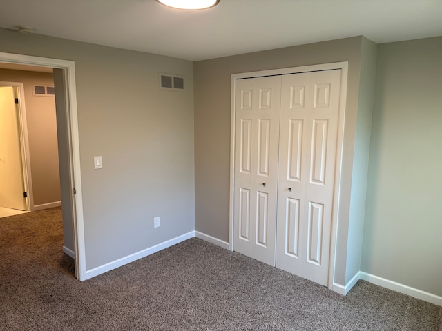 unfurnished bedroom featuring carpet floors, a closet, and baseboards