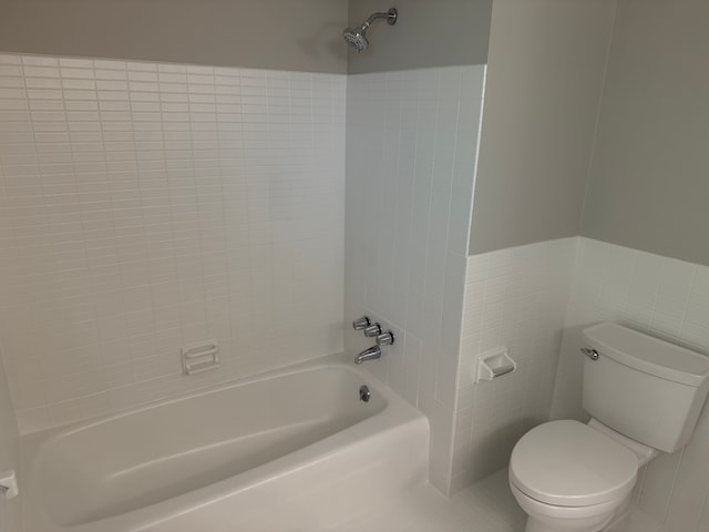 full bathroom featuring toilet, shower / bath combination, and tile walls