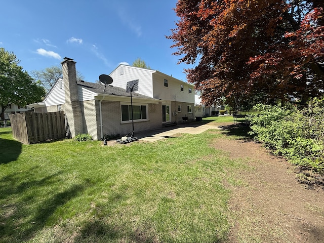 back of house with a patio, a chimney, and brick siding