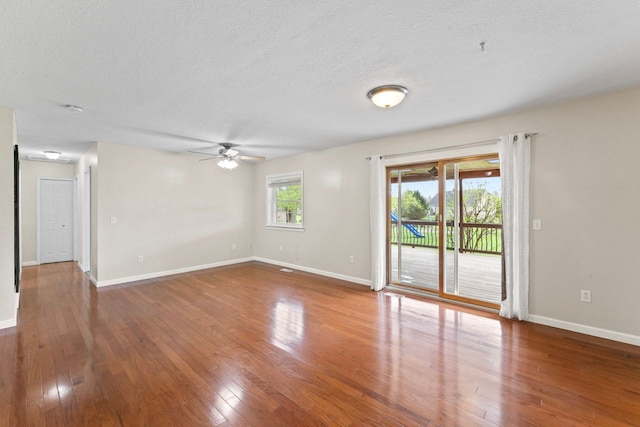 empty room with ceiling fan, hardwood / wood-style flooring, baseboards, and a textured ceiling