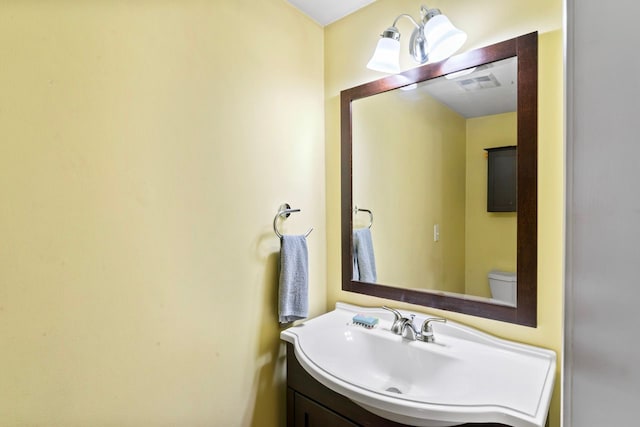 half bathroom with vanity and toilet