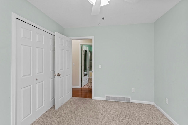 unfurnished bedroom with carpet, baseboards, a ceiling fan, and a closet