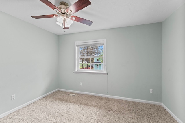carpeted empty room featuring baseboards and ceiling fan